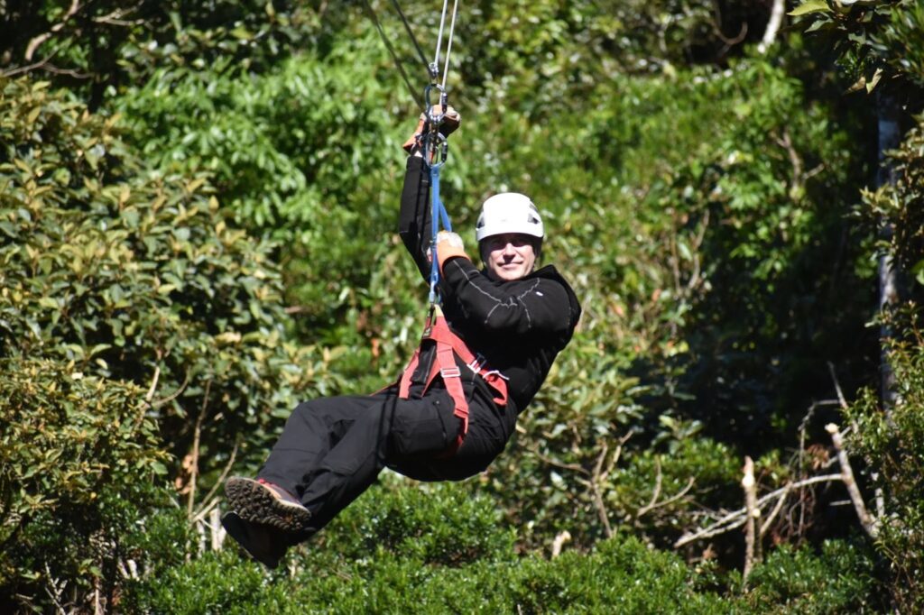 Woman ziplining through a rainforest canopy. 