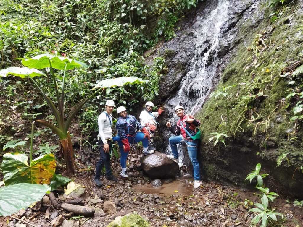 Tourists posing in front of a waterfall in Costa Rica.