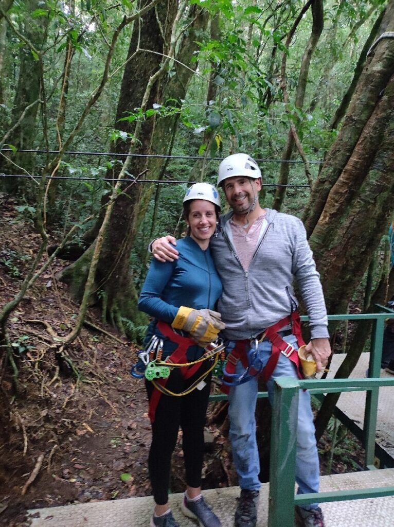 Couple wearing helmets and zipline gear before a Costa Rica rainforest canopy tour.